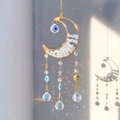 Golden moon crystal suncatcher with opal stones casting rainbow light on wall - Opalite
