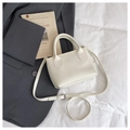 Bolso blanco con textura de lichi, perlas y correa ajustable sobre una chaqueta gris - Blanco