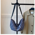 Detail of checkered canvas bag with cartoon bear print hanging on black clothes rack - Standard / Black