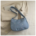 Détail d'un sac à bandoulière en jean bleu avec broderie de nœuds sur un blazer - Bleu clair