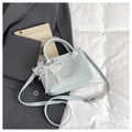 Close-up of light blue leather bucket bag with white lace bow and pearl charm detail - Blue (With Charm)