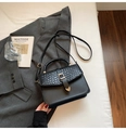Elegant black handbag with woven flap and gold metal buckle on minimalist background - Black