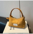 Detalle del bolso de ante color mostaza con asa de cuero y parche de marca tejido - Estilo básico / Marrón
