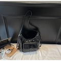 Detail einer glänzenden schwarzen Hobo-Tasche aus Kunstleder mit verstellbarem Gurt - Schwarz