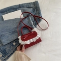 Rode mini crossbodytas met strikdetail en witte kantafwerking op denim achtergrond - Rood
