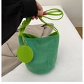 Borsa a secchiello verde brillante in camoscio con tracolla intrecciata e ciondolo - Verde
