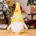 Gnomo natalizio di peluche con cappello giallo lavorato a maglia e barba bianca su un tavolo - Giallo