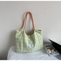 Detail of green and white checkered tote bag featuring orange braided rope handles and logo - Green