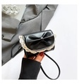 Detail of black mini crossbody bag featuring a large bow and white lace trim detail - Black