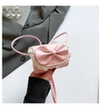 Close-up of pink mini crossbody bag with a large bow and white lace trim detail - Pink