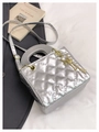 Detailansicht der silbernen gesteppten Mini-Tasche mit Goldkette und Schlüsselanhängern - Mit Anhänger / Silber