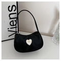 Close-up of black crescent bag featuring a white heart patch with a golden bow detail - Black