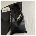Dettaglio della borsa hobo nera con borchie argentate su pelle opaca in stile chic - Nero
