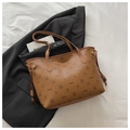 Detail of brown faux leather tote bag with pattern on a grey blazer over white fabric - Brown