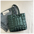Primer plano detallado del bolso tote acolchado verde oscuro con acabado metálico - Verde