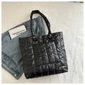 Detalle de bolso tote acolchado negro con costuras verticales y bolsillo delantero - Negro