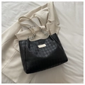 Dettaglio della borsa tote trapuntata con catene argentate su un blazer di stile - Bianco