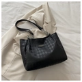 Dettaglio borsa shopper nera con trama a scacchi e catena argento su abito beige - Nero