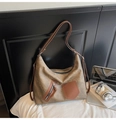 Dettaglio ravvicinato di una grande borsa tote con trama invecchiata e tasche con cerniera - Marrone