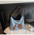 Dettaglio della borsa a tracolla in denim azzurro con tasche in pelle marrone e tracolla - Blu