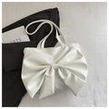 Primer plano de bolso tote blanco con lazo en cuero sintético suave y fondo minimalista - Blanco