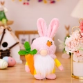 Pink and yellow Easter gnome plush with long ears holding a stuffed carrot on wooden table - Pink Bunny Gnome (With Carrot)