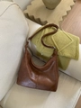Vintage brown leather hobo shoulder bag with adjustable strap on a cozy sofa - Brown
