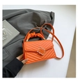 Detail of orange chevron quilted handbag featuring a modern square metal lock and pleats - Orange