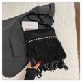 Detail of black fringe crossbody bag with gold studs on a minimalist flat lay background - Black
