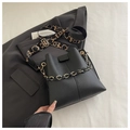 Detail of black lychee grain bucket bag featuring a thick metal chain and patterned strap - Black