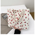 Beige corduroy tote bag featuring red strawberry prints with dual shoulder straps - White