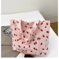 Pink corduroy tote bag featuring red strawberry prints and soft dual handles - Pink
