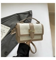 Detalle de bolso beige con relieve geométrico y cierre de broche metálico dorado fino - Caqui Oscuro