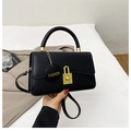 Chic black crossbody handbag featuring a golden lock and minimalist vegan leather design - Black