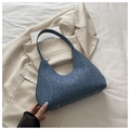Blue leopard print hobo bag showing bottom metal studs on light beige fabric - Blue Leopard