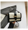 Detail of contrast handbag featuring white embossed triangles and gold metal buckle - Black and White