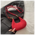 Dettaglio della borsa a mezzaluna in camoscio rosso con arco sagomato e fibbia dorata - Rosso