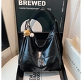Detail of glossy black tote bag featuring crinkled patent leather and baseball charm - With Pendant / Black