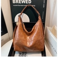 Retro brown leather hobo bag with fringe detail on a premium display shelf - With Pendant / Brown