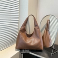 Bolso tote marrón de cuero tejido con gran capacidad en un entorno minimalista - Marrón