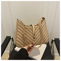 Detail einer beigen Umhängetasche mit V-Steppmuster und goldenem Metallverschluss - Khaki