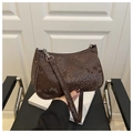 Detail shot of a dark brown snakeskin faux leather baguette bag with silver zippers - Brown