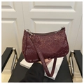 Detail showing high-gloss burgundy lizard texture leather on the shoulder bag - Red