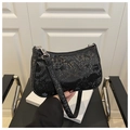 Detail view of the black snake pattern leather texture and silver hardware on a baguette bag - Black