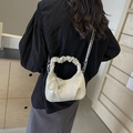 Bolso chic de charol blanco con lazo de perlas y cadena metálica mostrado en modelo - Blanco Roto