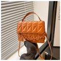 Macro detail of the orange quilted leather crossbody bag with decorative thick chain link - Brown
