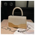Close-up of sparkling rhinestone evening bag with silver chain on marble surface - Gold