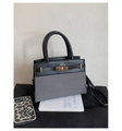 Dettaglio ravvicinato di una borsa bicolore in pelle nera e tessuto intrecciato grigio - Nero