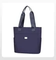 Detalle de bolso tote de nailon azul con bolsillo frontal y placa metálica de logo - Azul