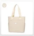 Macro detail of beige tote bag showing high-quality canvas texture and front zipper pocket - Beige